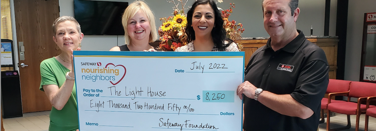 Light House and Safeway staff holding a check