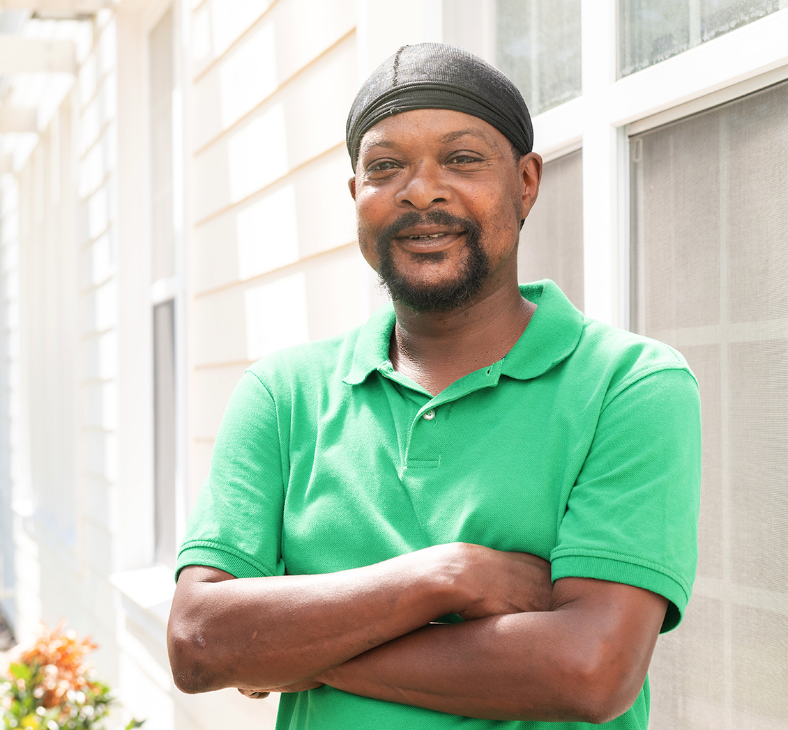 Photo of Reggie in front of The Light House wearing a green shirt